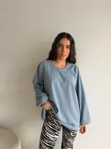 Buzo de punto acanalado color celeste, con cuello redondo y mangas largas holgadas de corte amplio.