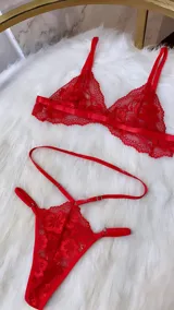 Conjunto de lencería de cuatro piezas en color rojo, confeccionado en encaje. Incluye bralette, tanga de tiro alto con tiras ajustables, portaligas y ligas para las piernas.