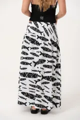 Maxi pollera de lino con corte tipo caderín y frunces, de silueta levemente acampanada y tiro medio-bajo. Presenta un estampado exclusivo de peces en color negro sobre fondo blanco.