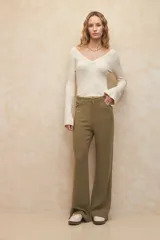 Pantalón de lino color verde oliva, de corte recto y tiro alto, con costuras marcadas en el centro de cada pierna.