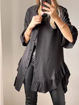 Camisa negra de tejido suave tipo seda, con manga tres cuartos y volados irregulares en mangas y ruedo.