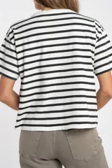 Remera de corte oversize confeccionada en algodón lavado, con diseño de rayas horizontales en color negro sobre fondo crudo, cuello redondo y mangas cortas.