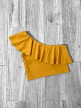 Top corto con un solo hombro y volado grande.