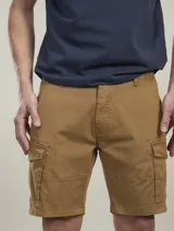 Bermuda cargo color marrón camel, confeccionada en twill con spandex, de calce cómodo y tiro medio. Cuenta con bolsillos laterales con solapa y bolsillos traseros con botón.