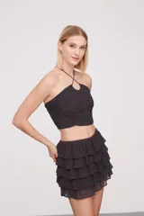 Top gris oscuro con cuello halter, fruncido y con pequeñas tachas.