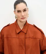 Campera bomber de gamuza sintética color terracota, con cuello clásico, cierre frontal, hombros caídos y puños ajustados.
