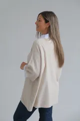 Sweter de punto color beige, con corte holgado, cuello redondo y mangas tres cuartos.