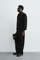 Sobrecamisa de corte cropped confeccionada en terciopelo con elasticidad. Presenta cuello solapa, cierre frontal con cremallera metálica, bolsillos de vivo en la cadera y mangas largas con puños abotonados.