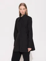 Camisa negra de algodón y poliéster, corte evasé, cuello clásico y mangas largas con puños abotonados.