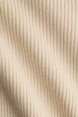 Top entallado de punto acanalado color beige, con escote bote y mangas largas con aberturas en los puños.