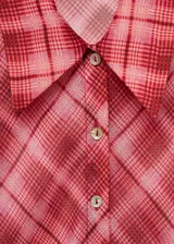 Camisa de tejido fluido con estampado de cuadros en tonos rojizos, diseño recto, cuello camisero y manga larga con puños abotonados.