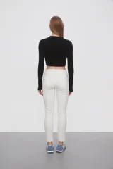 Pantalon de jean negro, corte skinny y tiro medio, con cierre frontal y bolsillos laterales.