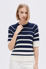 Remera de punto de algodón, de manga corta, con diseño a rayas horizontales en azul marino y blanco, cuello redondo y calce holgado.