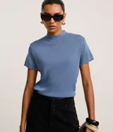 Blusa de punto texturizado color celeste, de manga corta y cuello alto, marca Cortelle.