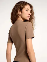 Blusa de cuello alto y manga corta, confeccionada en tela acanalada de ajuste entallado.