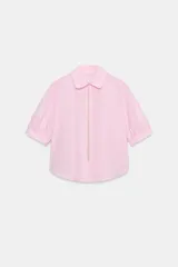 Camisa de popelina color rosado, con cuello redondo amplio, manga corta abullonada y detalle de bordado decorativo con perlas en la botonera frontal oculta.