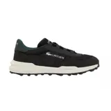 Championes Lacoste modelo Elite Active Evo, color negro con detalles en verde oscuro y suela blanca. Diseño deportivo con paneles de tela y refuerzos de gamuza, logo de la marca en el lateral y en la lengüeta.