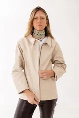 Campera de cuero color crema con cierre frontal, cuello camisero y diseño de corte recto con costuras verticales decorativas.