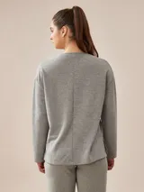 Buzo de manga larga a rayas horizontales color beige y blanco.