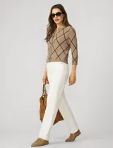 Cardigan tejido negro con estampado de rombos blancos, cuello redondo y cierre frontal con botones dorados. Marca Cable & Gauge.