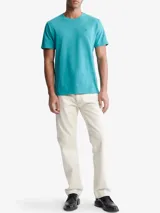 Remera de manga corta de algodón color turquesa, con cuello redondo y un pequeño monograma bordado en el pecho.