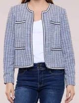Chaqueta de tweed azul con tejido estructurado, escote redondo, bolsillos simulados con pasamanería y botones decorativos en las mangas.