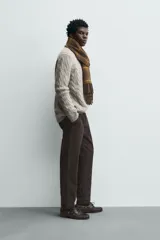 Pantalón chino de corte ajustado, color beige, con bolsillos laterales y bolsillos traseros de vivo. Cuenta con cierre frontal de cremallera y botón.
