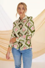 Camisa de manga larga con cuello clásico y cierre de botones. Estampado con motivos florales y geométricos en tonos crudo, azul y negro.