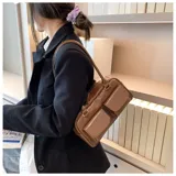 Cartera de cuero sintético color marrón, de diseño rectangular con doble asa superior para hombro, cierre principal con cremallera y dos bolsillos frontales externos con solapa.