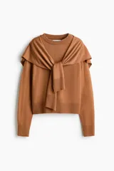 Sweater de punto fino color marrón, de cuello redondo con ribetes en canalé. Presenta un diseño que incluye un fular a juego anudado alrededor de los hombros, simulando el efecto de otro jersey sobrepuesto.