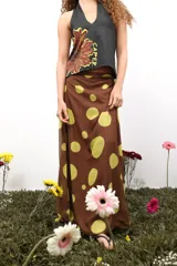 Falda larga de gasa con estampado tipográfico en tonos bordó sobre fondo beige. Presenta un diseño de doble tela con caída fluida y cierre lateral oculto.