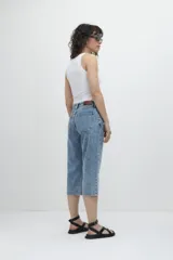 Pantalón capri de jean celeste con efecto lavado, tiro alto, corte recto y largo a la pantorrilla.
