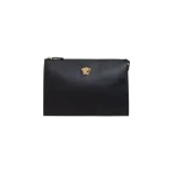 Clutch de cuero negro con cierre superior y placa metálica dorada de la cabeza de Medusa de Versace en la parte frontal.