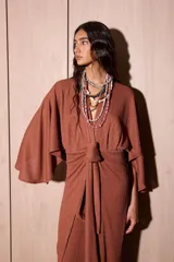 Vestido largo marrón tipo kimono en crepé texturado, con mangas amplias abiertas y tiras ajustables para atar en la cintura.