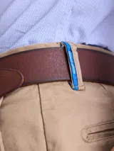 Pantalón de gabardina color azul marino, de corte recto y estilo clásico, con cierre de botón y cremallera, y trabillas para cinturón.