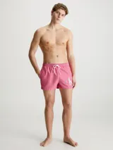 Short de baño corto color rosado con cintura elástica ajustable con cordón blanco y logo CK plateado estampado en la pierna derecha.