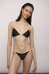 Conjunto de bikini compuesto por un corpiño triangular y una bombacha de corte clásico, ambos en color negro con bordes en contraste color amarillo.