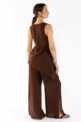 Pantalón ancho de color marrón, con pretina elástica, bolsillos laterales y aberturas en los bajos. Confeccionado en tejido fluido.