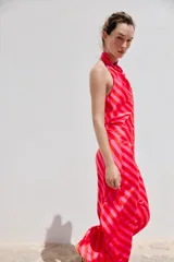 Top satinado sin mangas con cuello halter y estampado de rayas diagonales en tonos rojo y rosado.