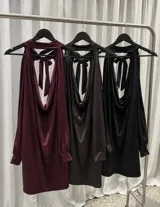 Vestido corto negro de satén con diseño halter, escote drapeado y mangas largas acampanadas. Incluye un cinturón de cadena metálica decorativo en la cintura.