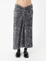 Falda midi negra cubierta de lentejuelas doradas.