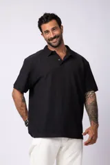 Chomba de manga corta con cuello polo, confeccionada en tejido de punto acanalado de textura pesada. Presenta un calce relajado y cuenta con una pequeña etiqueta distintiva en el ruedo.