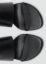 Sandalias de tacón alto color negro, con diseño destalonado, tira ancha superior y tira fina en la parte delantera.