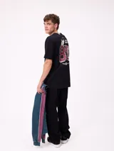 Remera de corte holgado color crema con estampado gráfico en la espalda que incluye el número 85, personajes animados y la frase Play Hard, Surf Harder.