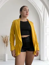 Blazer amarillo mostaza de crepe con solapas y bolsillos delanteros.