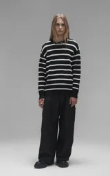 Sweater de cuello redondo con diseño de rayas horizontales en blanco y negro. Confeccionado en tejido de punto con textura suave, corte oversize y terminaciones en punto rib en cuello, puños y ruedo.