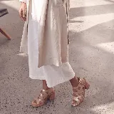 Sandalias de cuero color marrón, con taco ancho, diseño de tiras cruzadas y hebilla metálica de ajuste en el tobillo.