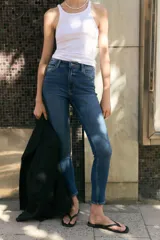 Jean skinny de tiro alto en denim azul con efecto deslavado y leve elasticidad, corte ajustado de cadera a tobillo, con diseño clásico de cinco bolsillos y cierre frontal con botón y cremallera.