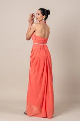 Vestido largo de fiesta color salmón, con cuello halter, corte imperio, falda con movimiento y cinturón blanco fino con hebilla circular.