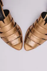 Sandalias de cuero negro con talón descubierto, tiras anchas entrecruzadas en el empeine y taco bajo de madera.